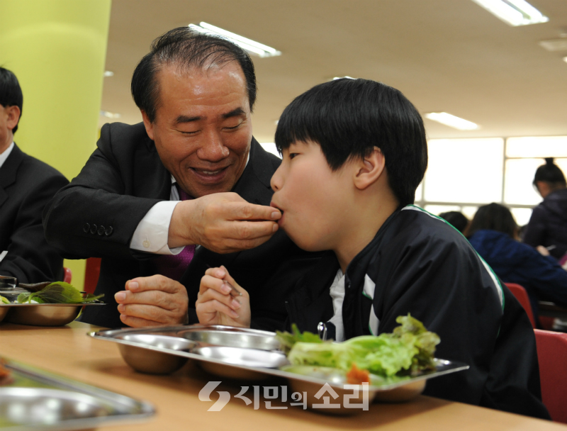 ▲한 초등학교에서 학생에게 음식을 먹여주고 있는 장휘국 예비후보(사진=광주시교육청).